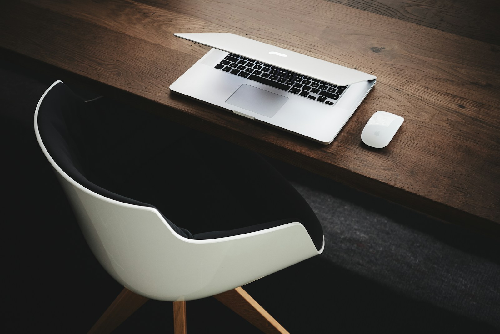 MacBook sobre escritorio de madera clara con decoración minimalista, estética limpia y contemporánea
