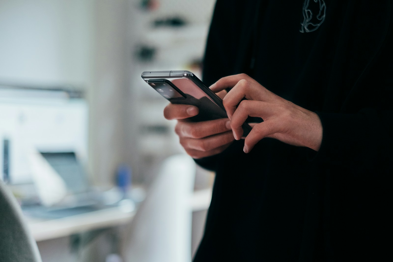 Mano sosteniendo un smartphone con una página web moderna perfectamente optimizada para mobile, con interfaz limpia e intuitiva