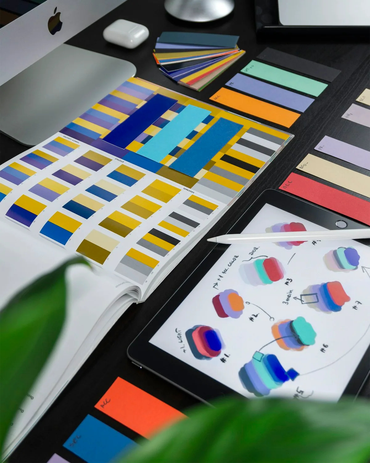 Muestras de color Pantone y materiales de diseño sobre escritorio, representando la importancia de un sistema visual coherente