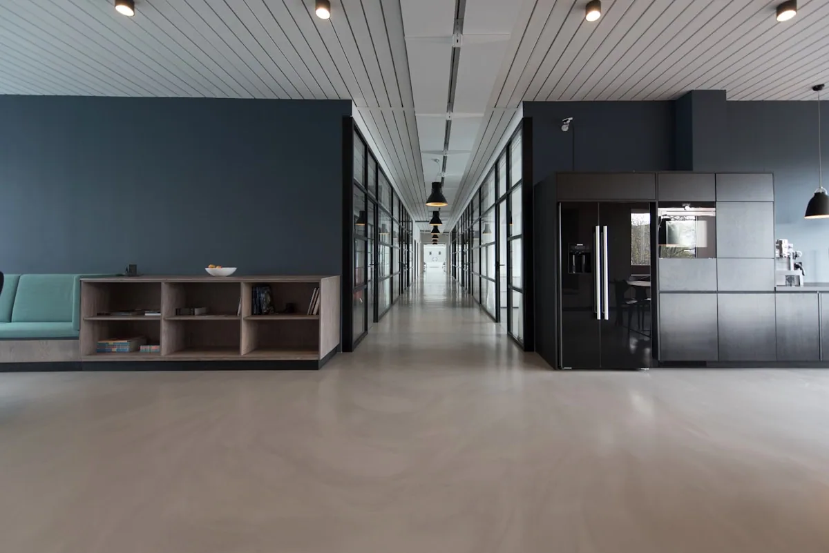 Corredor de oficina contemporánea con paneles de vidrio y diseño minimalista que transmite orden y profesionalismo