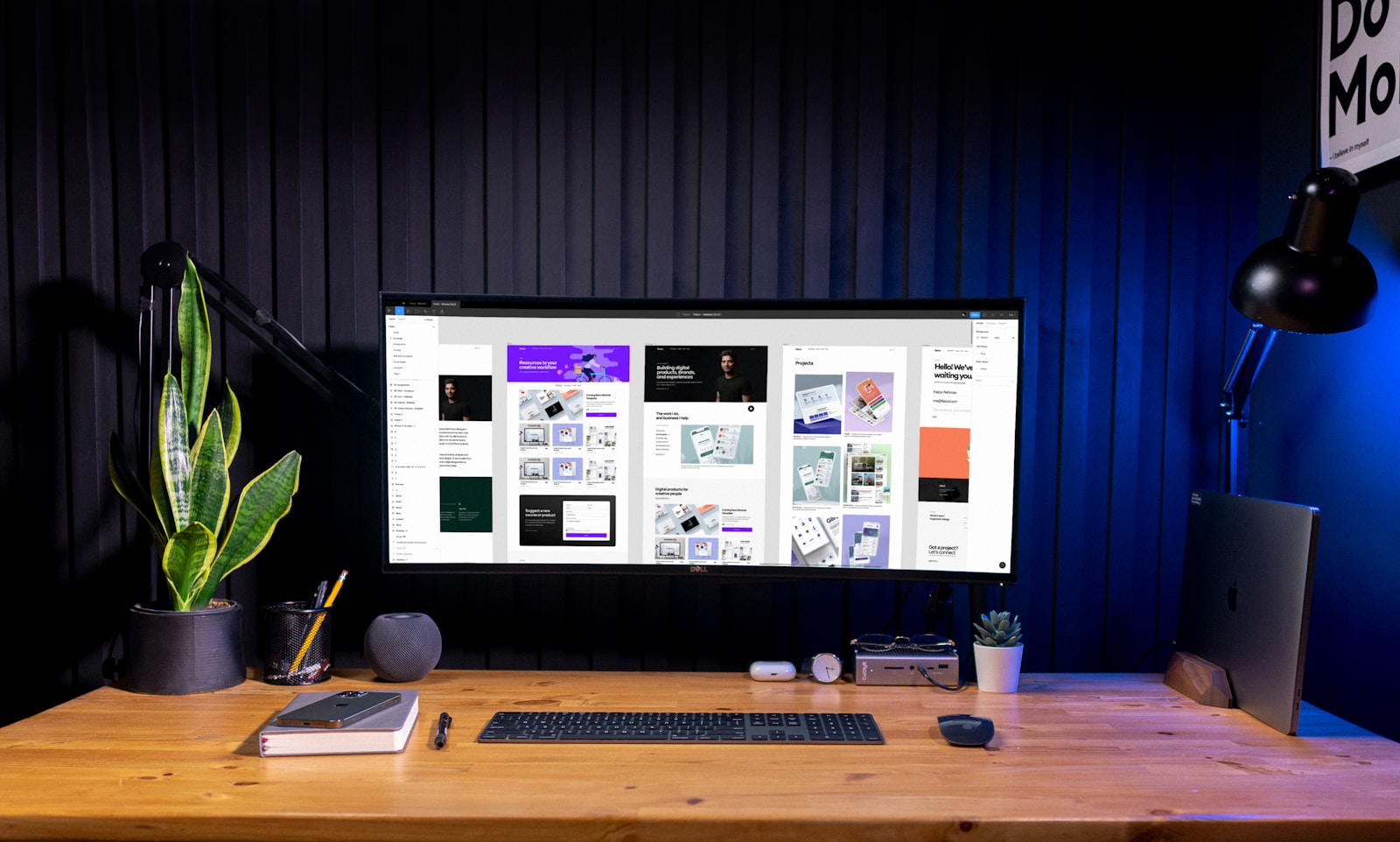 Monitor ultrawide mostrando múltiples diseños web modernos en una herramienta de diseño profesional, setup creativo